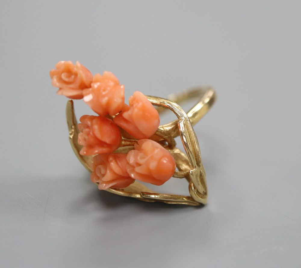A carved coral mounted ring, stamped 585, finger size M/N
